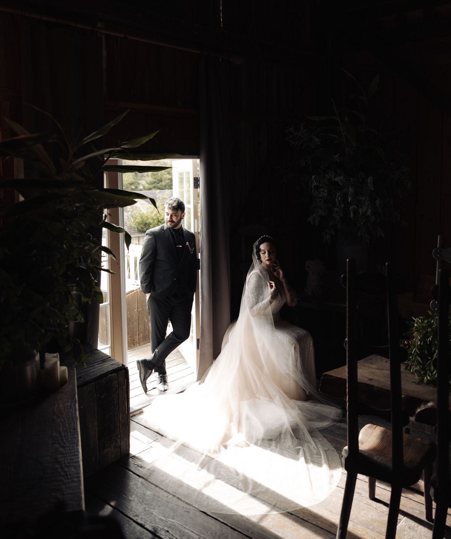 Dramatic lighting captures a wedding scene with shadows and light streaming through doorway.