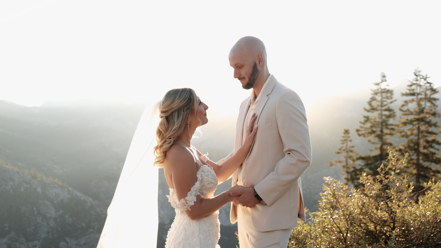 Couple sharing a romantic moment at a mountain overlook during golden hour wedding ceremony in Yosemite.