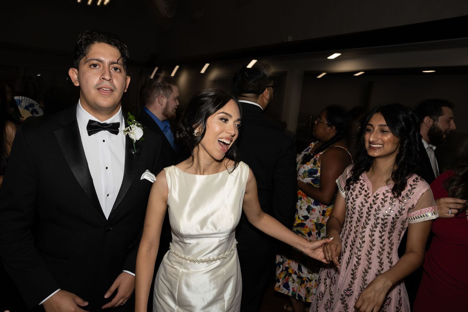 Wedding party members dancing and celebrating during the reception.
