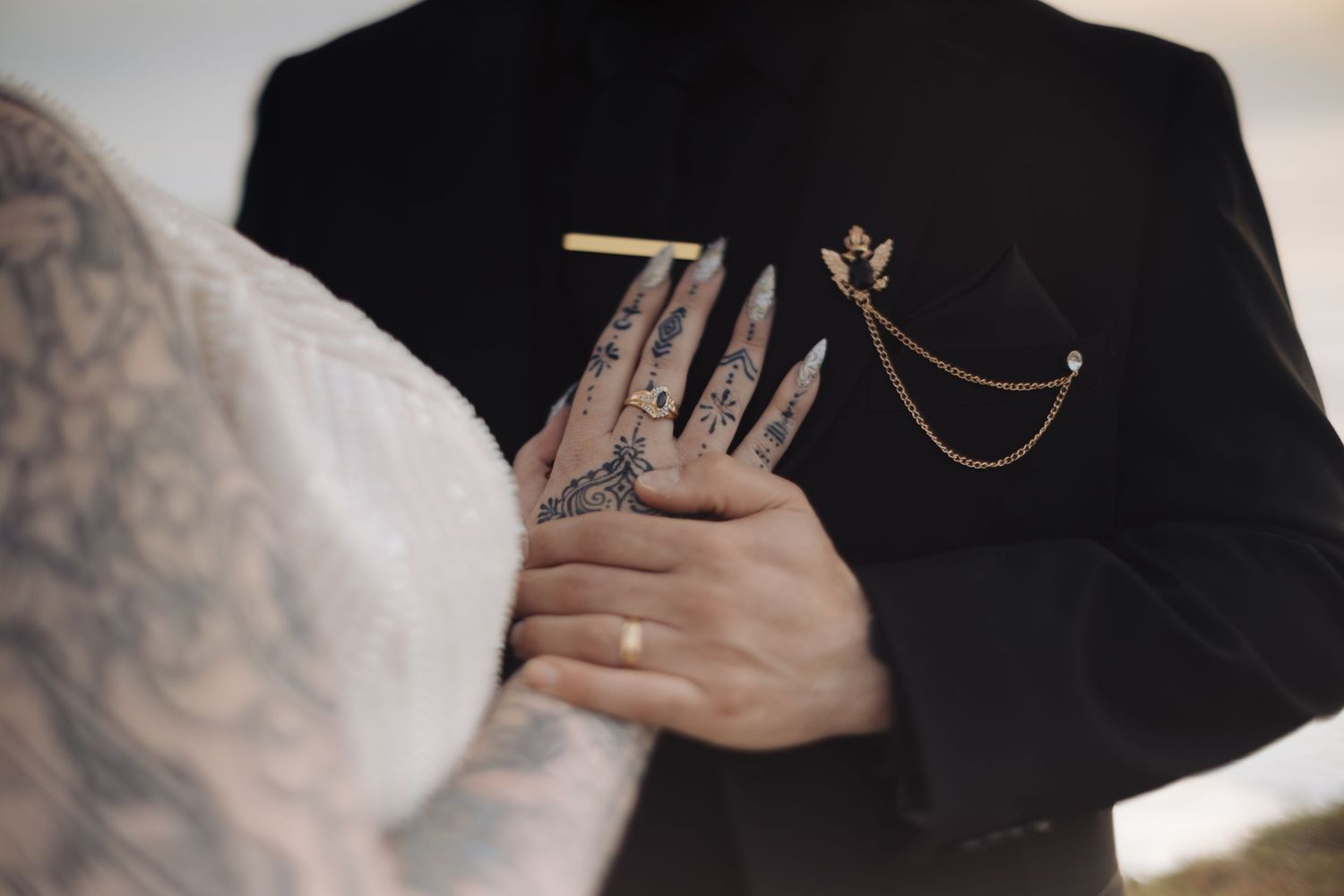 Artistic close-up details of black formal attire with delicate embellishments.
