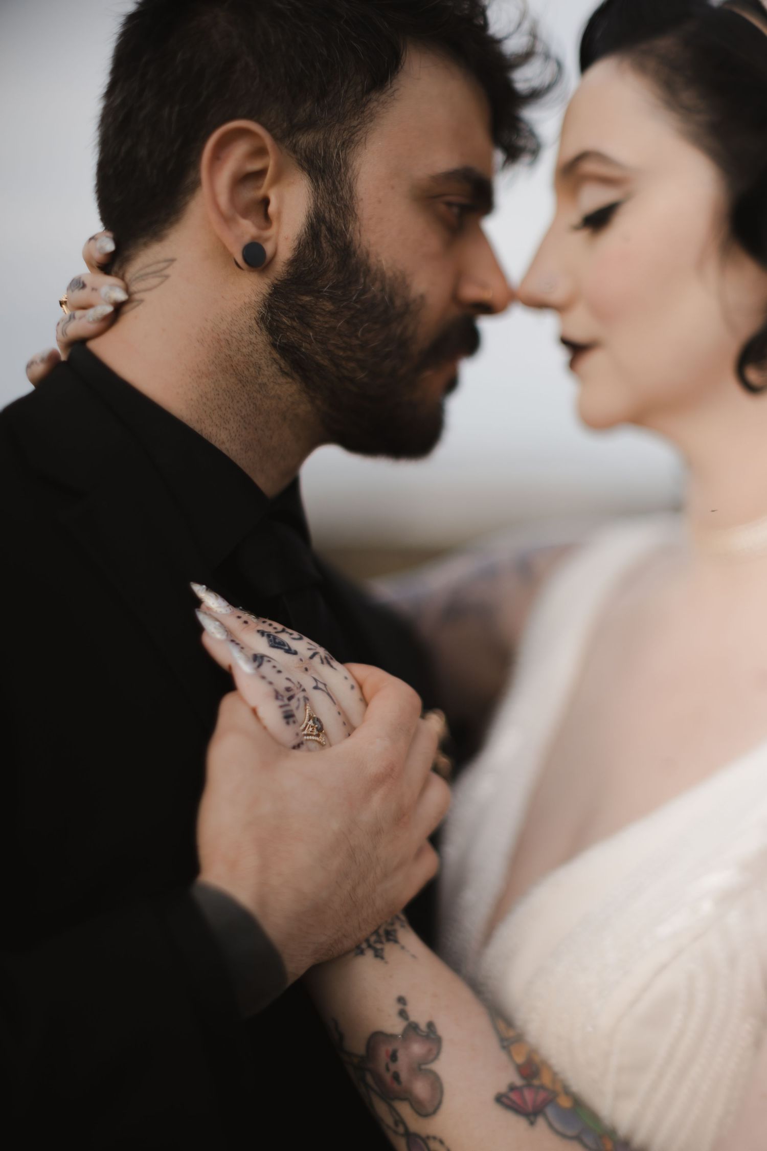 Close-up intimate portrait showing tattoos and romantic connection.