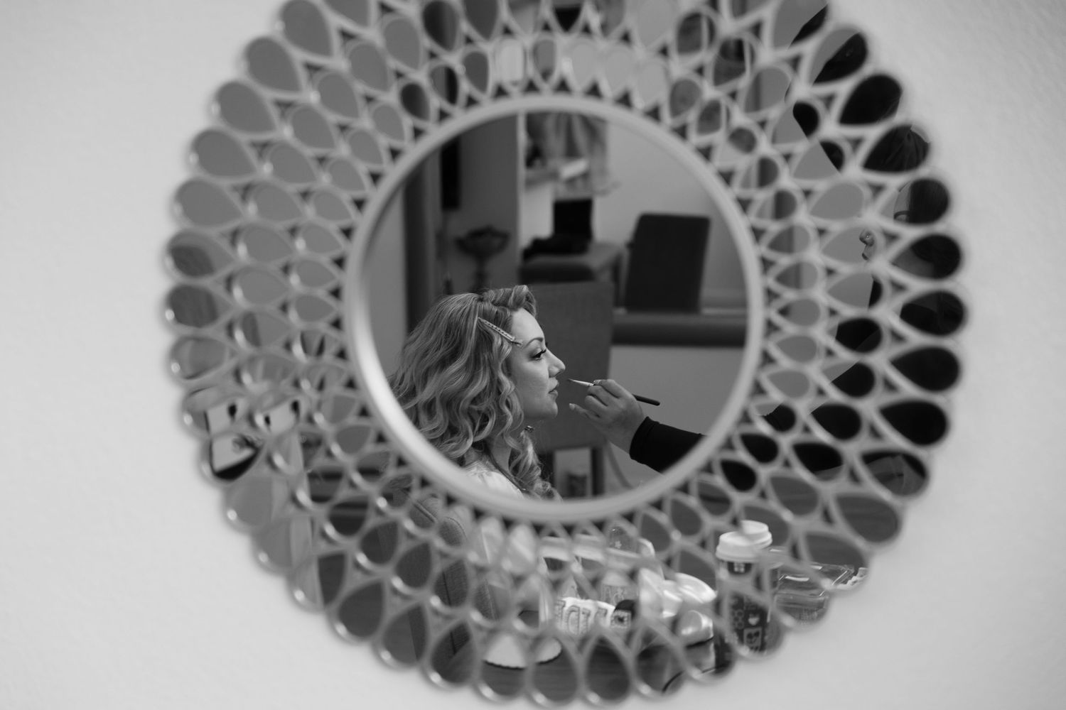 Decorative circular mirror with geometric cutout pattern in black and white.