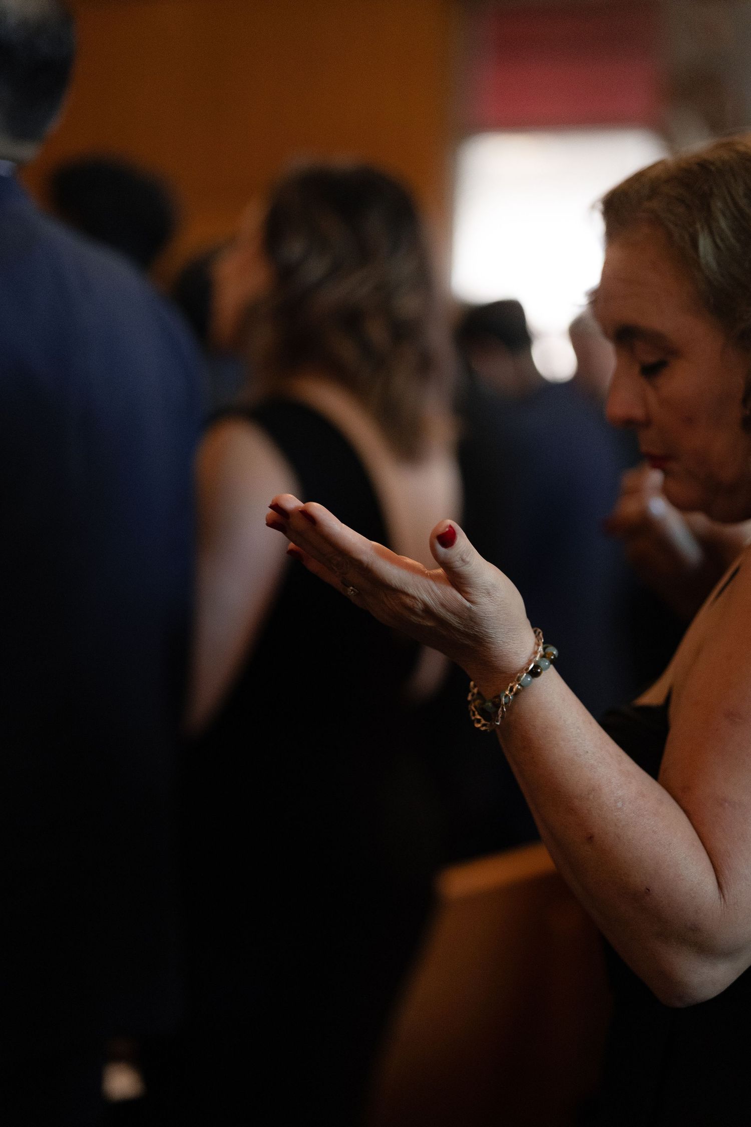 A close-up shot of hands clasped in prayer during a church service.