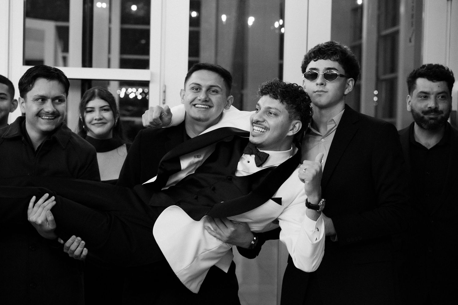 Wedding guests enjoy festivities at an indoor reception venue with modern decor.