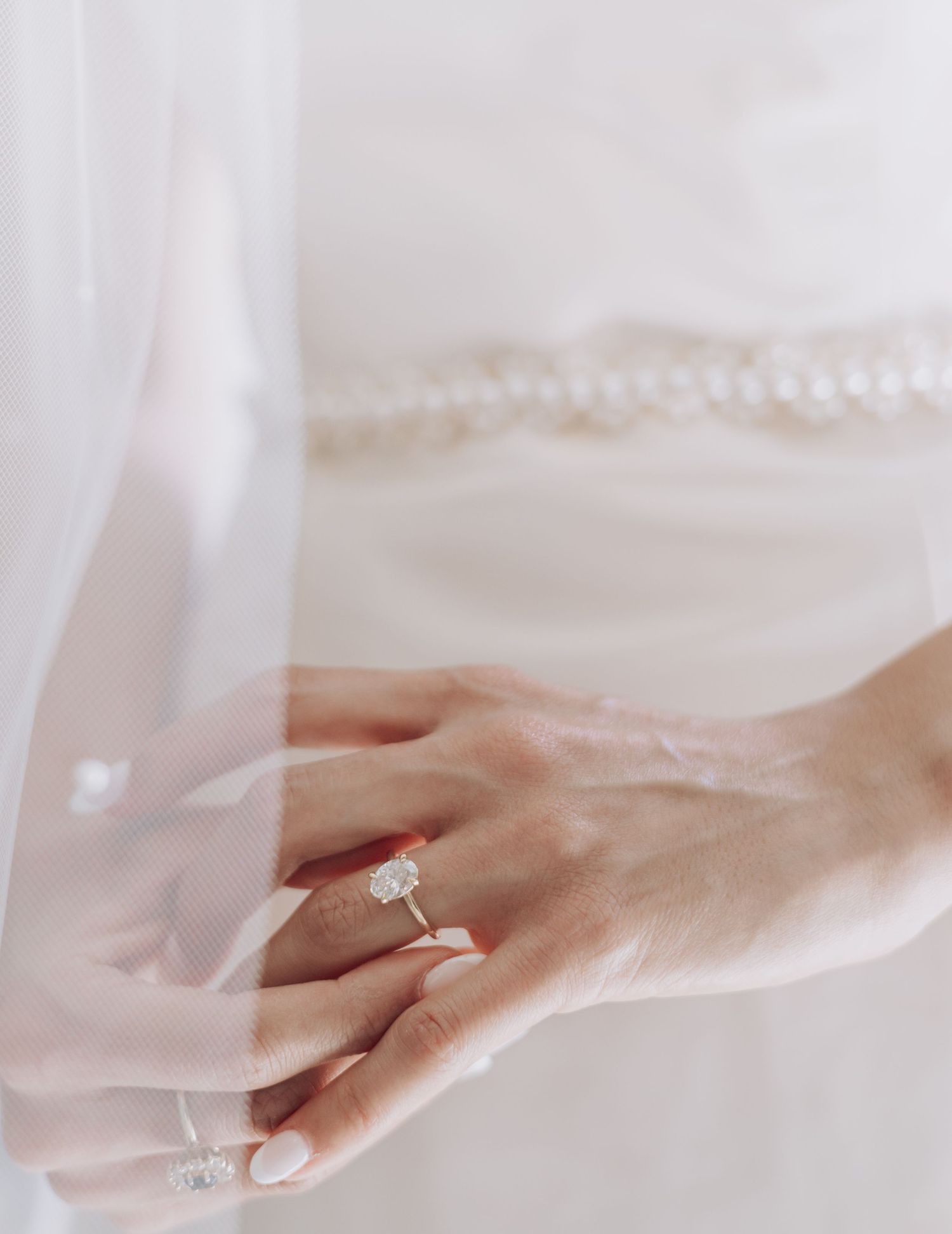 Elegant engagement ring and wedding band displayed on soft white fabric.