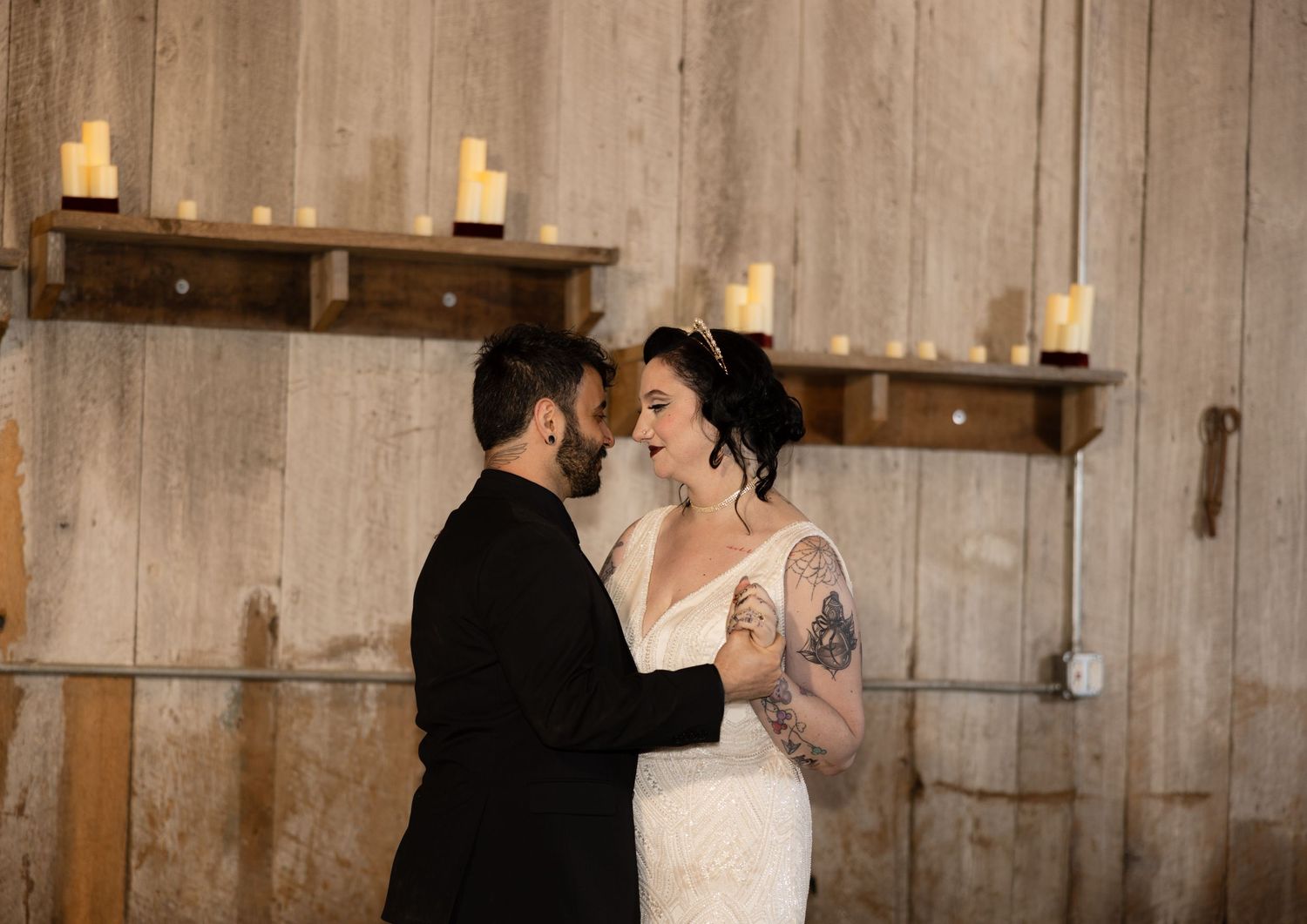 Romantic dance sequence in a rustic barn venue illuminated by soft candlelight.