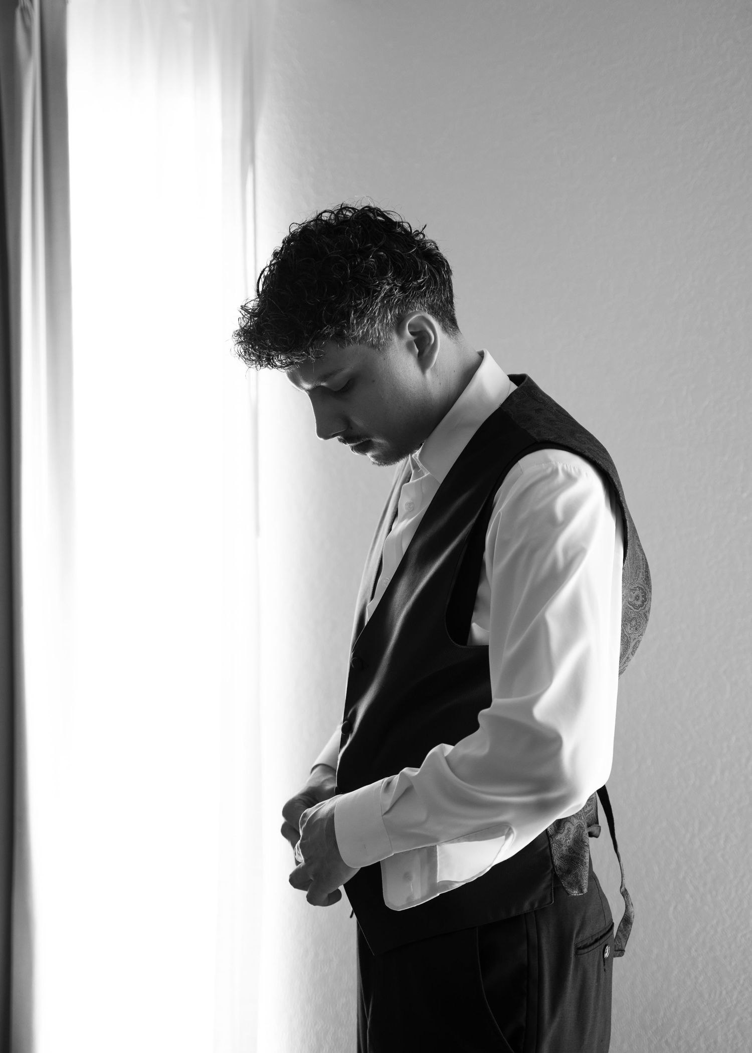 Person adjusting formal attire while getting dressed in black and white.