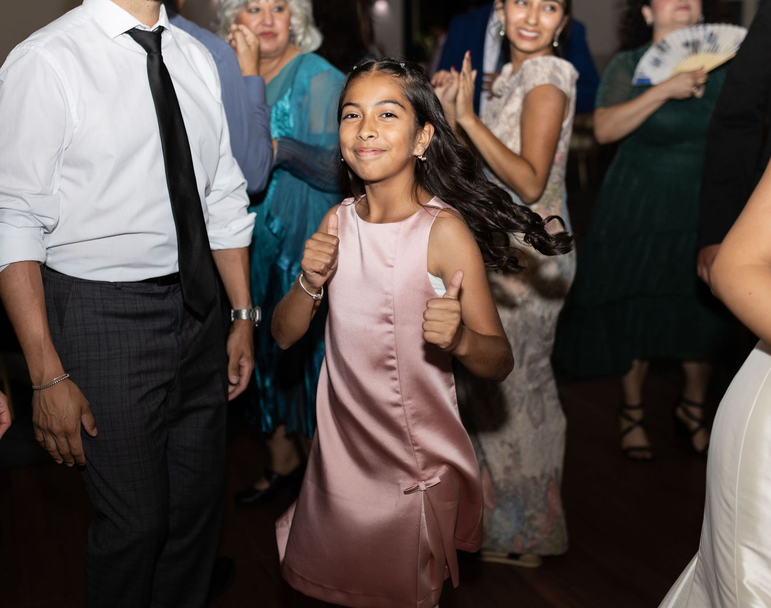 Guests dancing and celebrating at an indoor wedding reception.