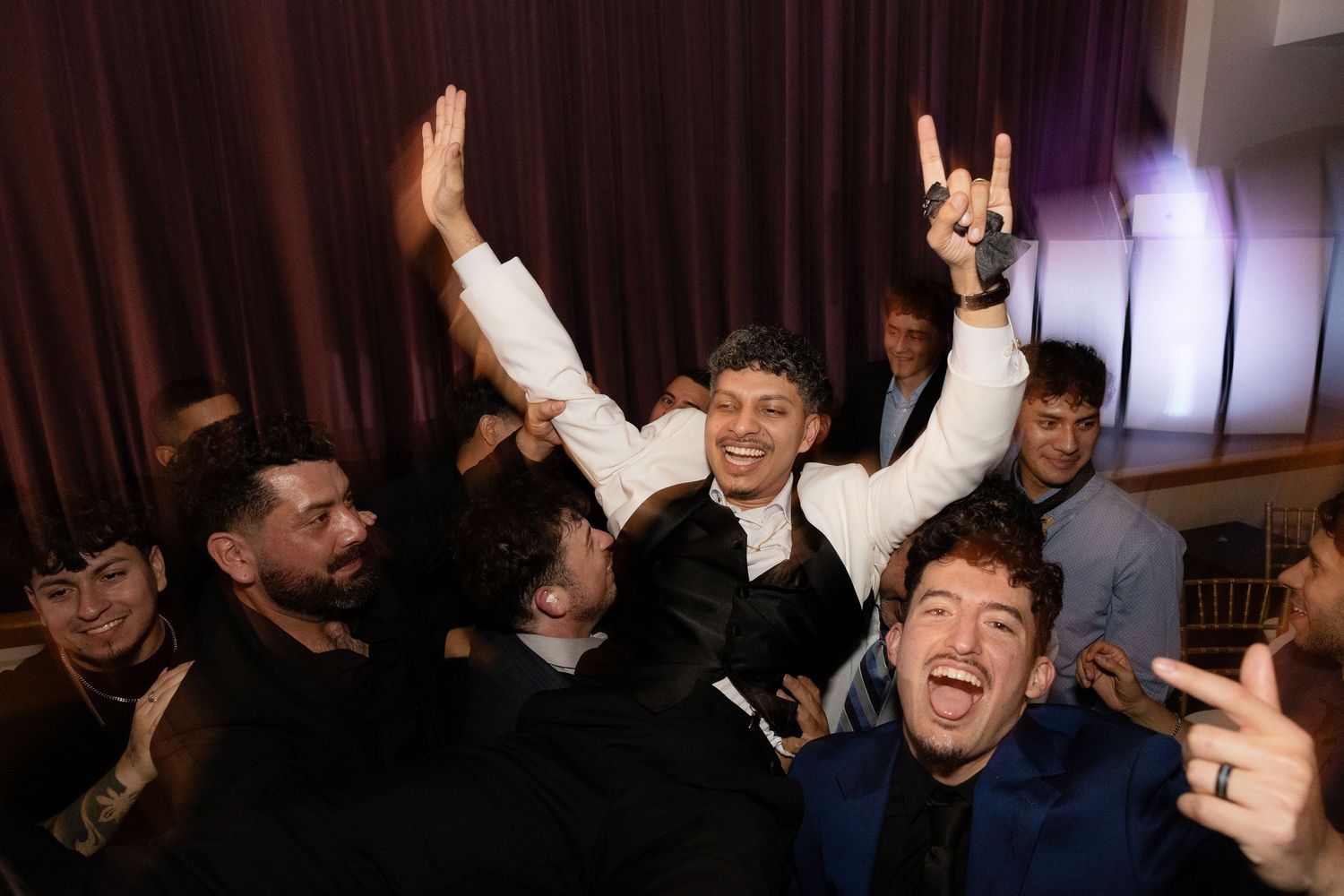 Wedding guests making celebratory gestures and poses for group photos.