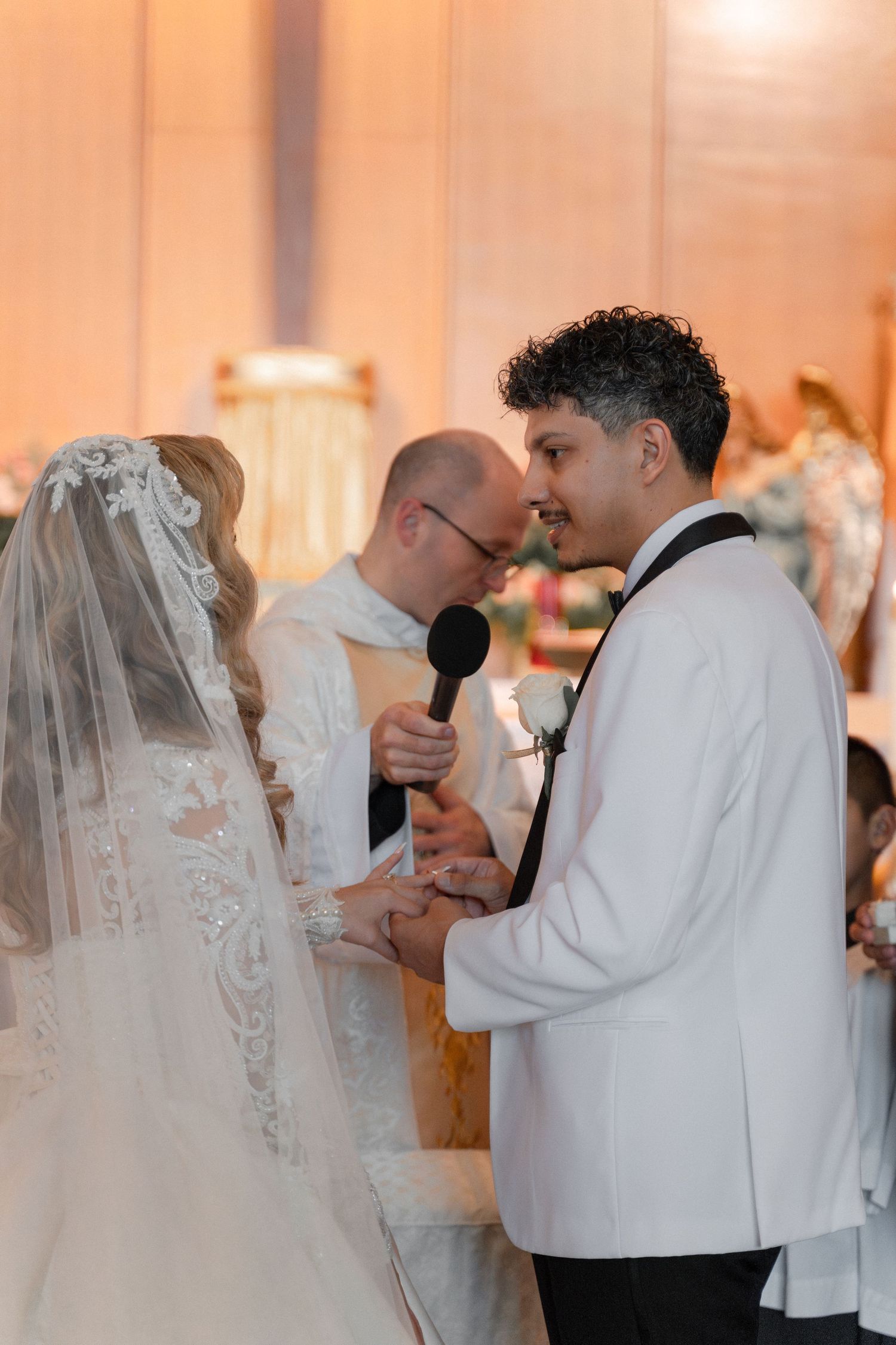 A wedding ceremony in progress with warm lighting and religious decor visible.