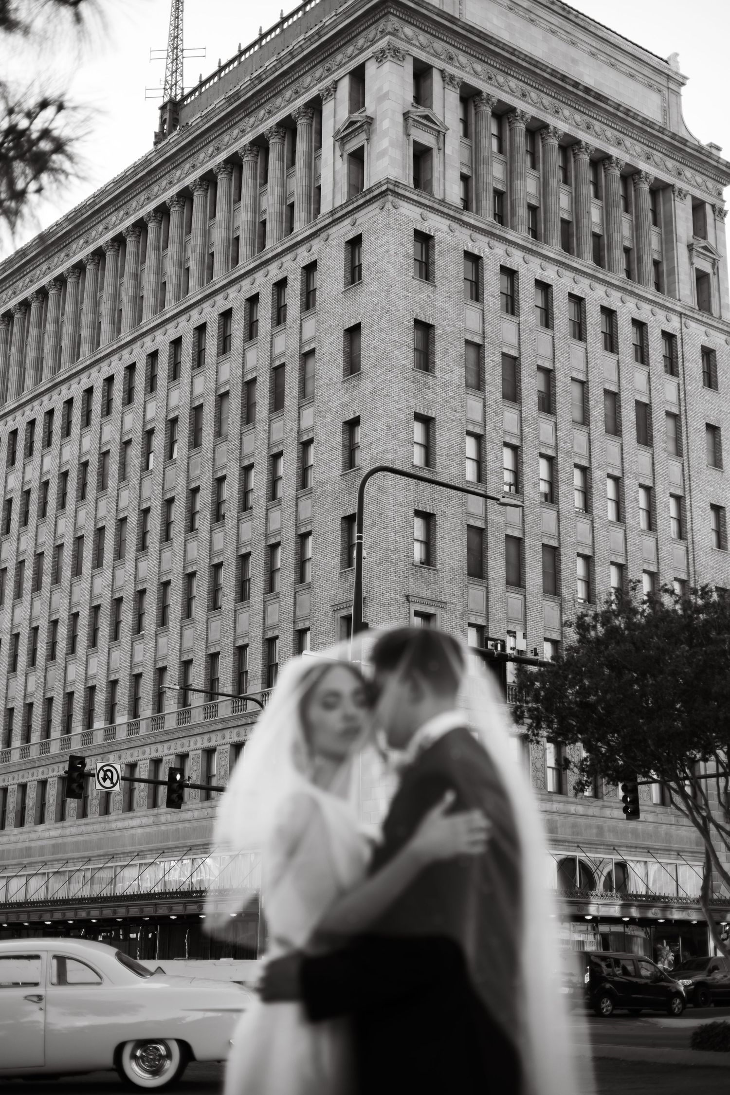 Black and white wedding photography showcases romantic moments against vintage architecture.