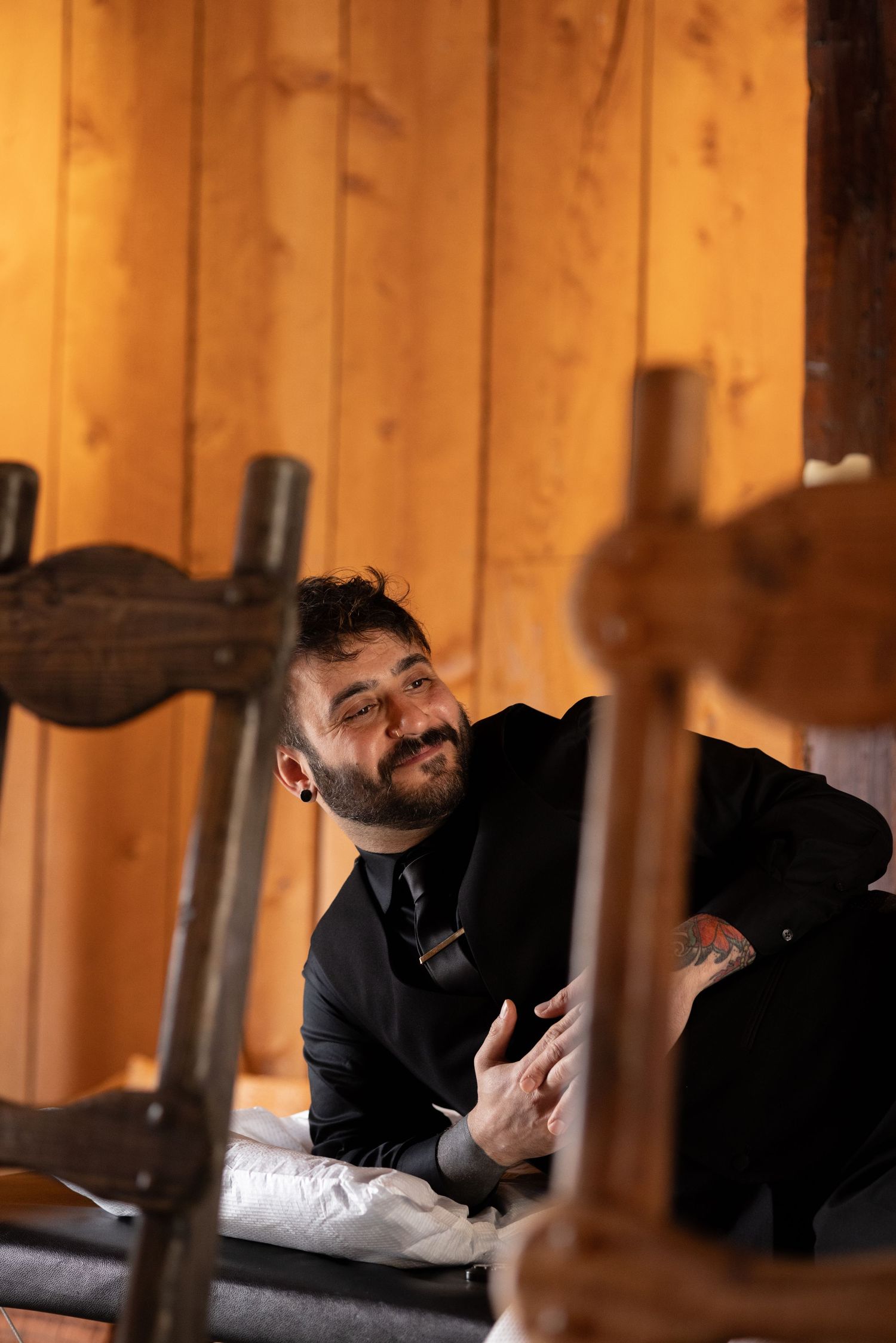 People relaxing on wooden benches in a rustic barn setting.