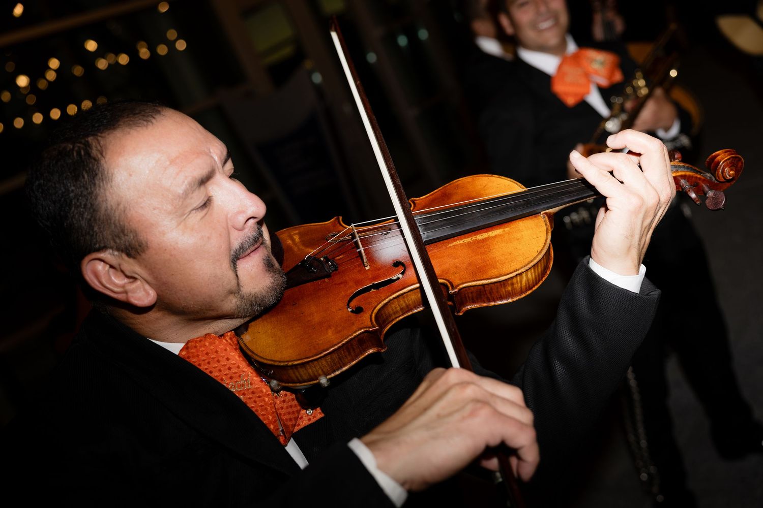 Musicians perform on violins during an elegant evening event.