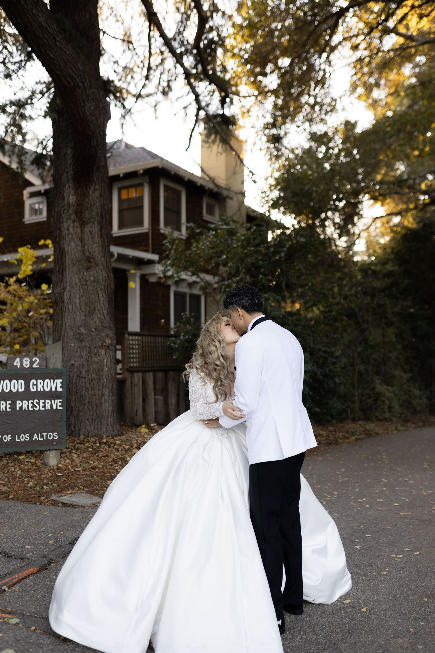 A romantic wedding moment captured at Redwood Grove Nature Preserve with a couple embracing on a fall day.