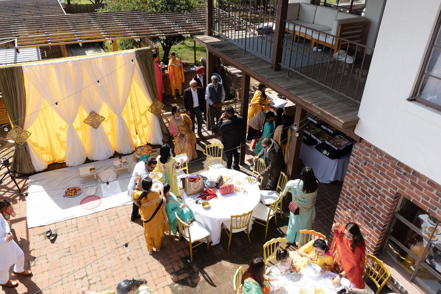 Aerial view of an outdoor market with vendors selling crafts and goods under white tents on a sunny day.