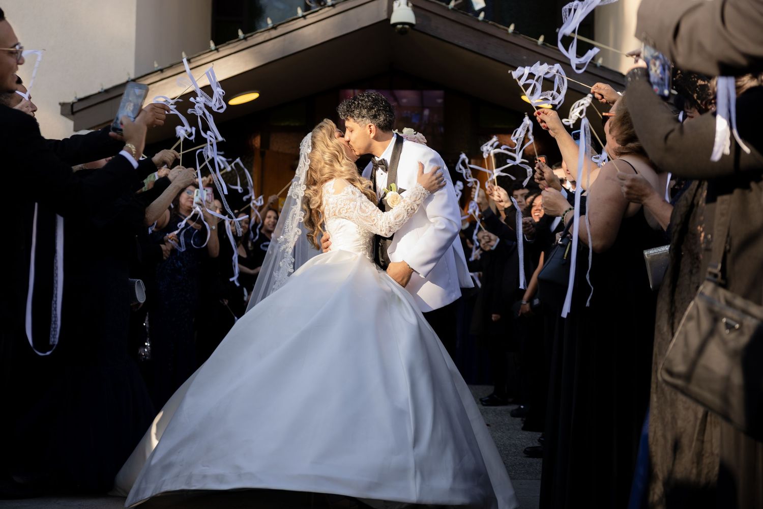 Guests hold sparklers creating a magical walkway during an evening wedding celebration.