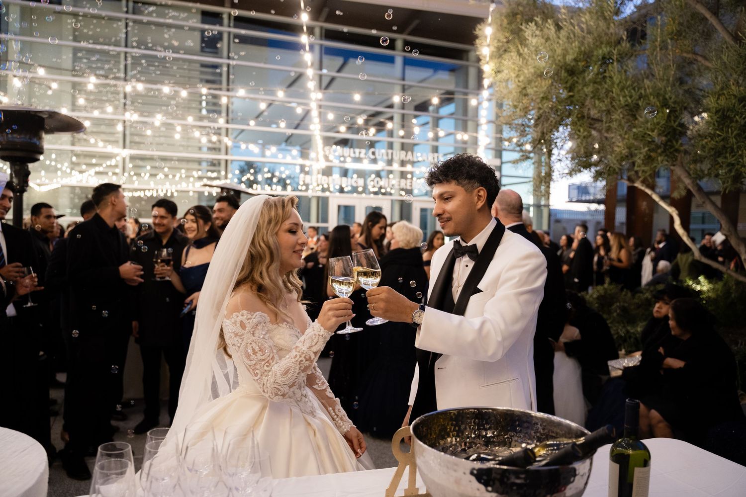 Wedding couple performs romantic dance moves beneath string lights at outdoor reception.