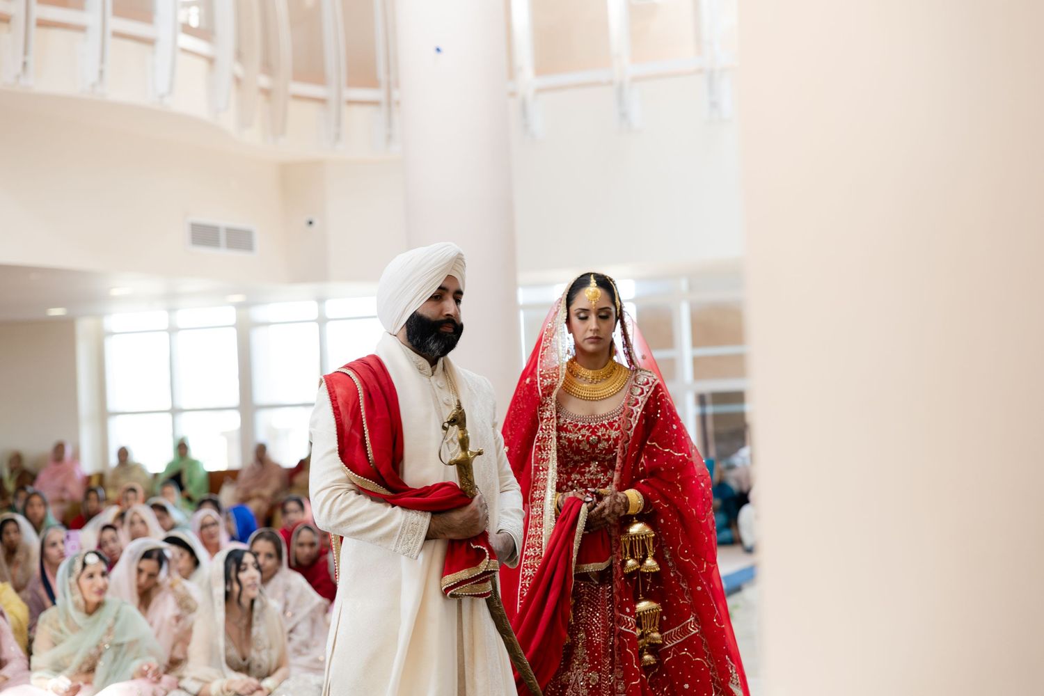 A traditional Indian wedding ceremony with guests gathered in a bright indoor venue during a cultural celebration.