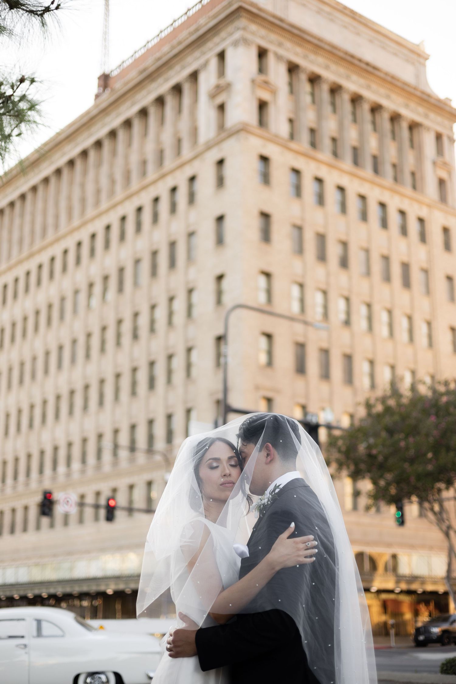 Elegant wedding couple shares tender moments outside a historic downtown building.