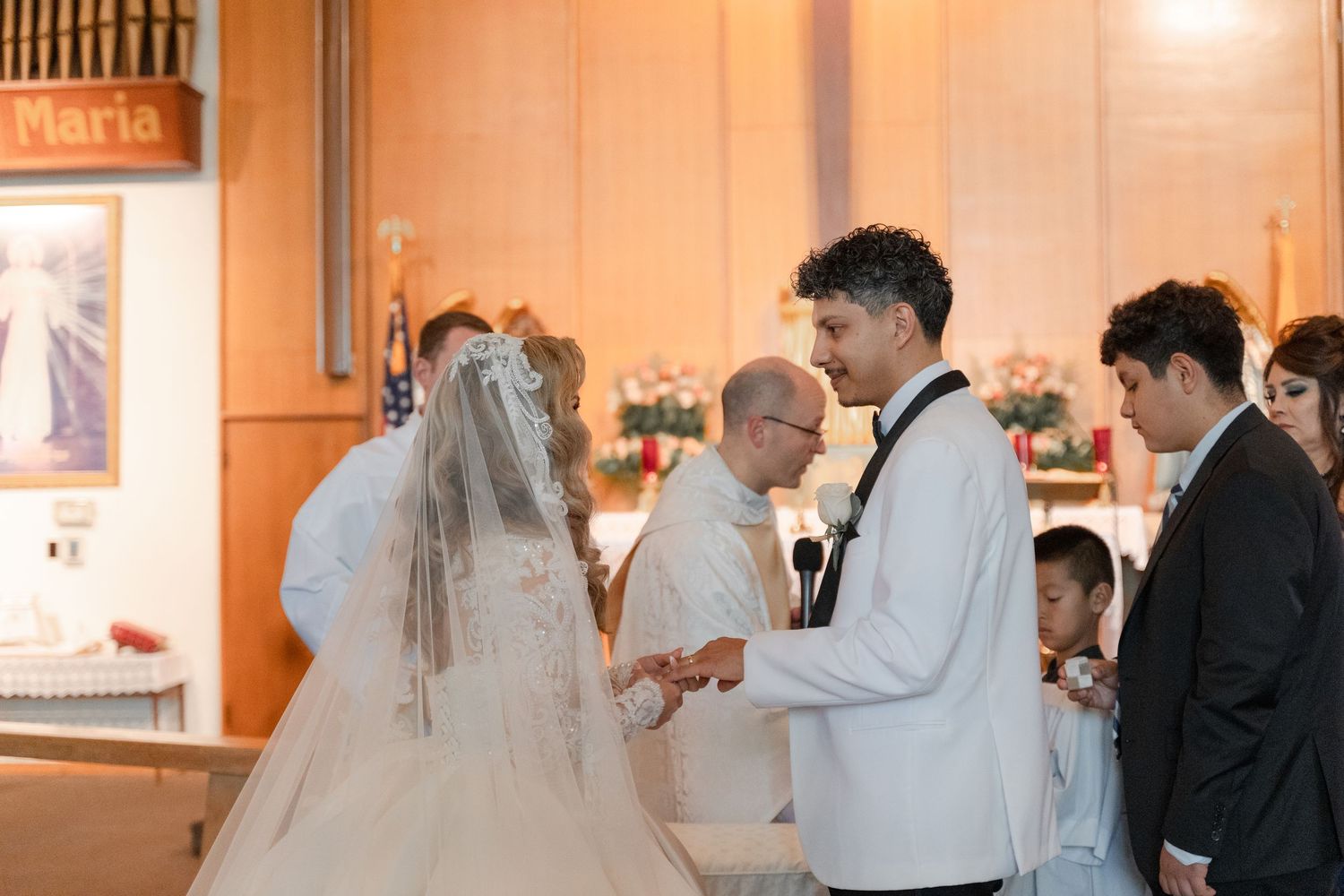 A wedding ceremony takes place at the altar with religious artwork visible in the background.
