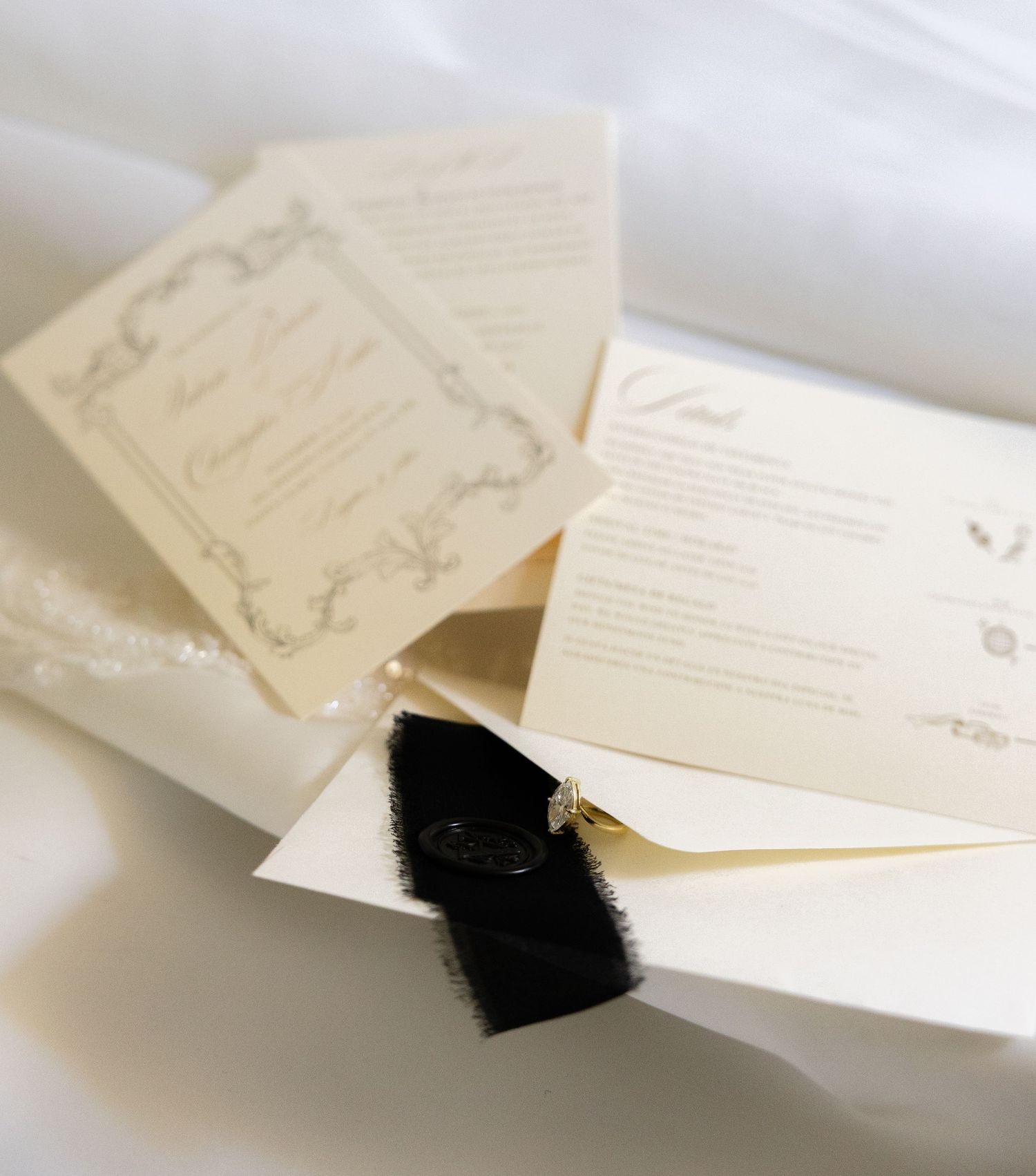 Elegant cream-colored wedding invitations arranged in a cascading layout.