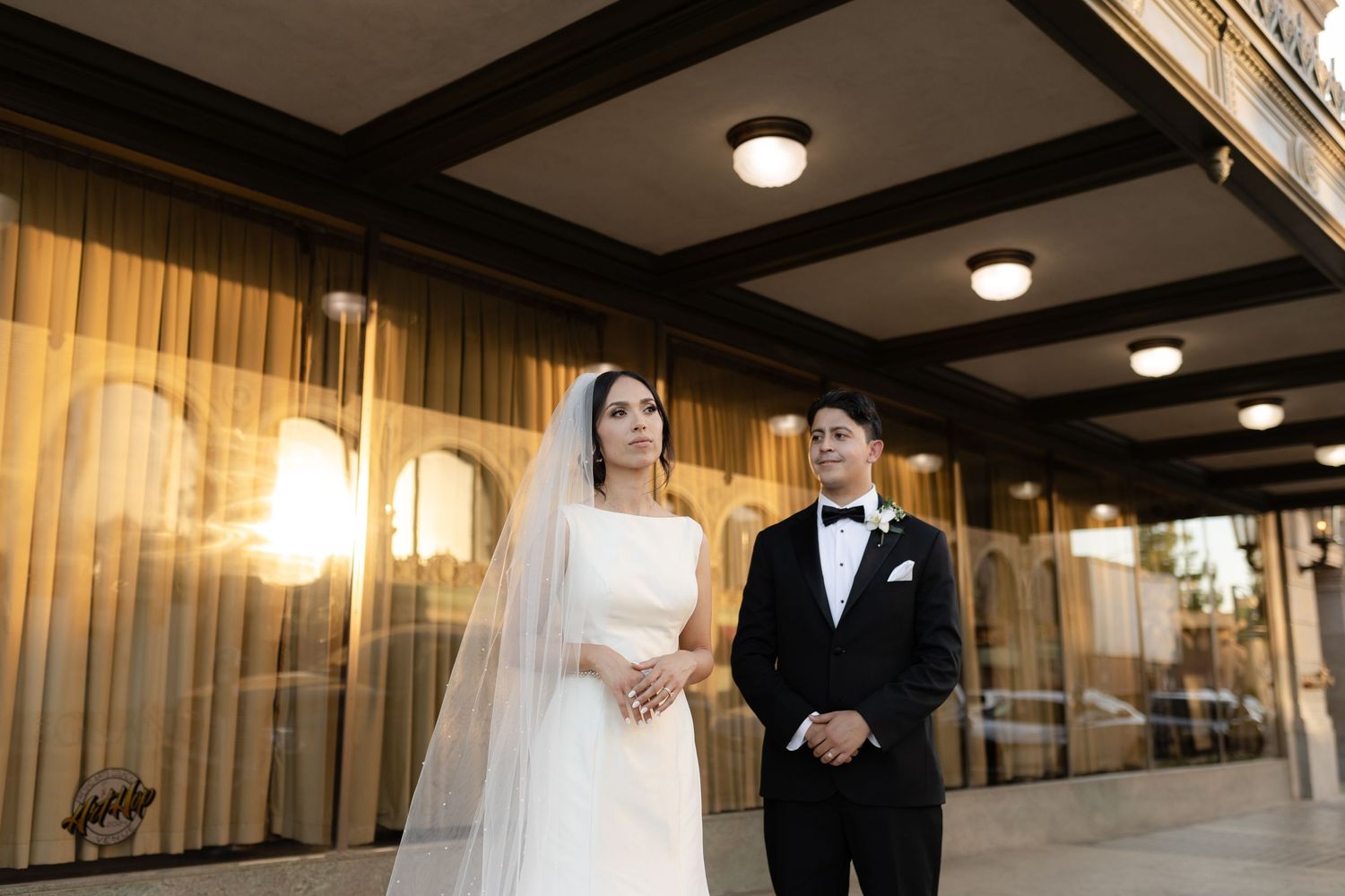 Couple in formal attire shares tender moments in an elegant indoor setting with warm lighting.