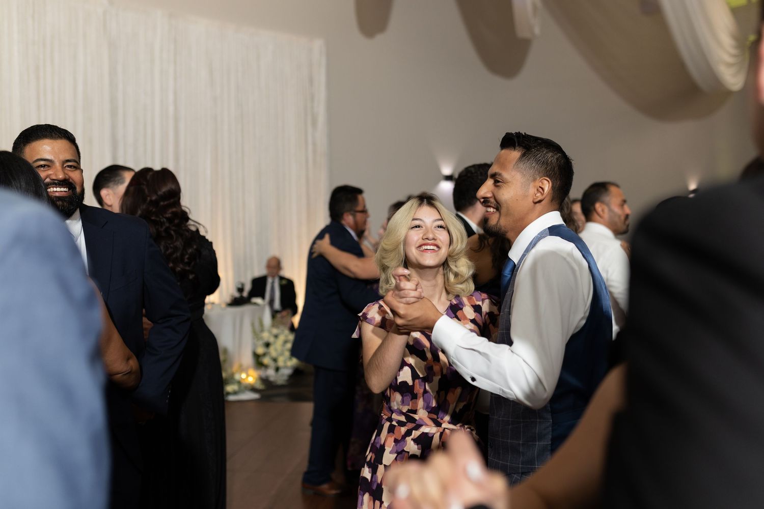 Joyful dancing and celebration captured during an indoor wedding reception.