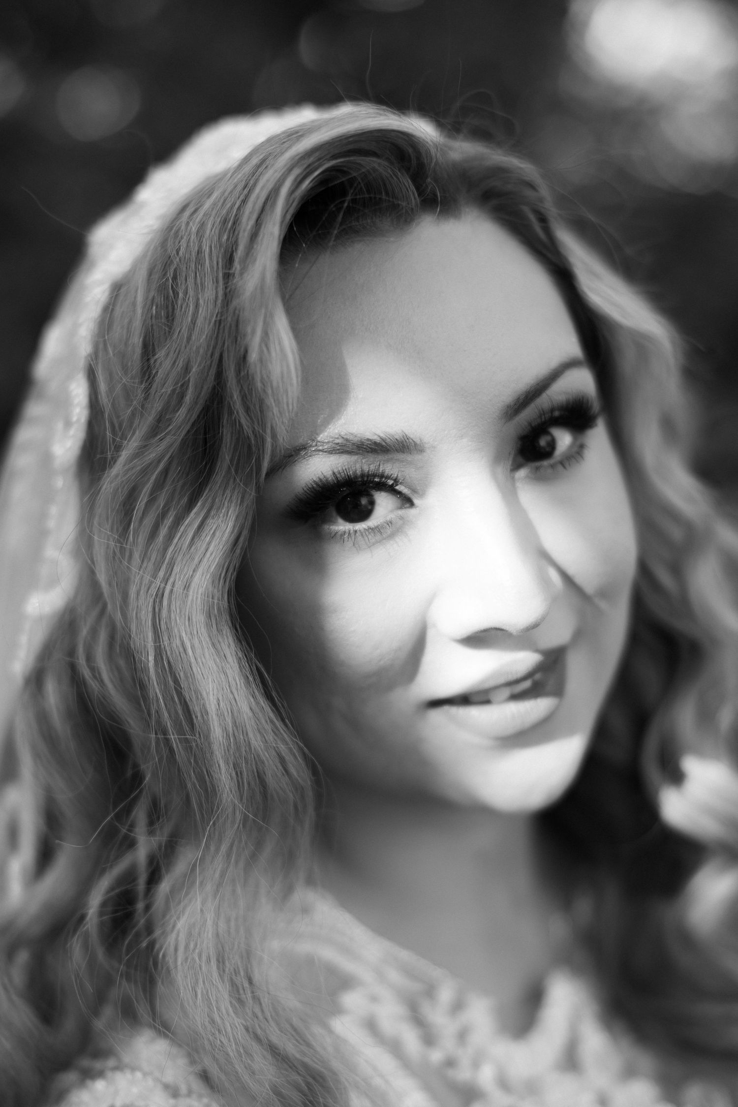 Artistic black and white bridal portrait with dramatic lighting.