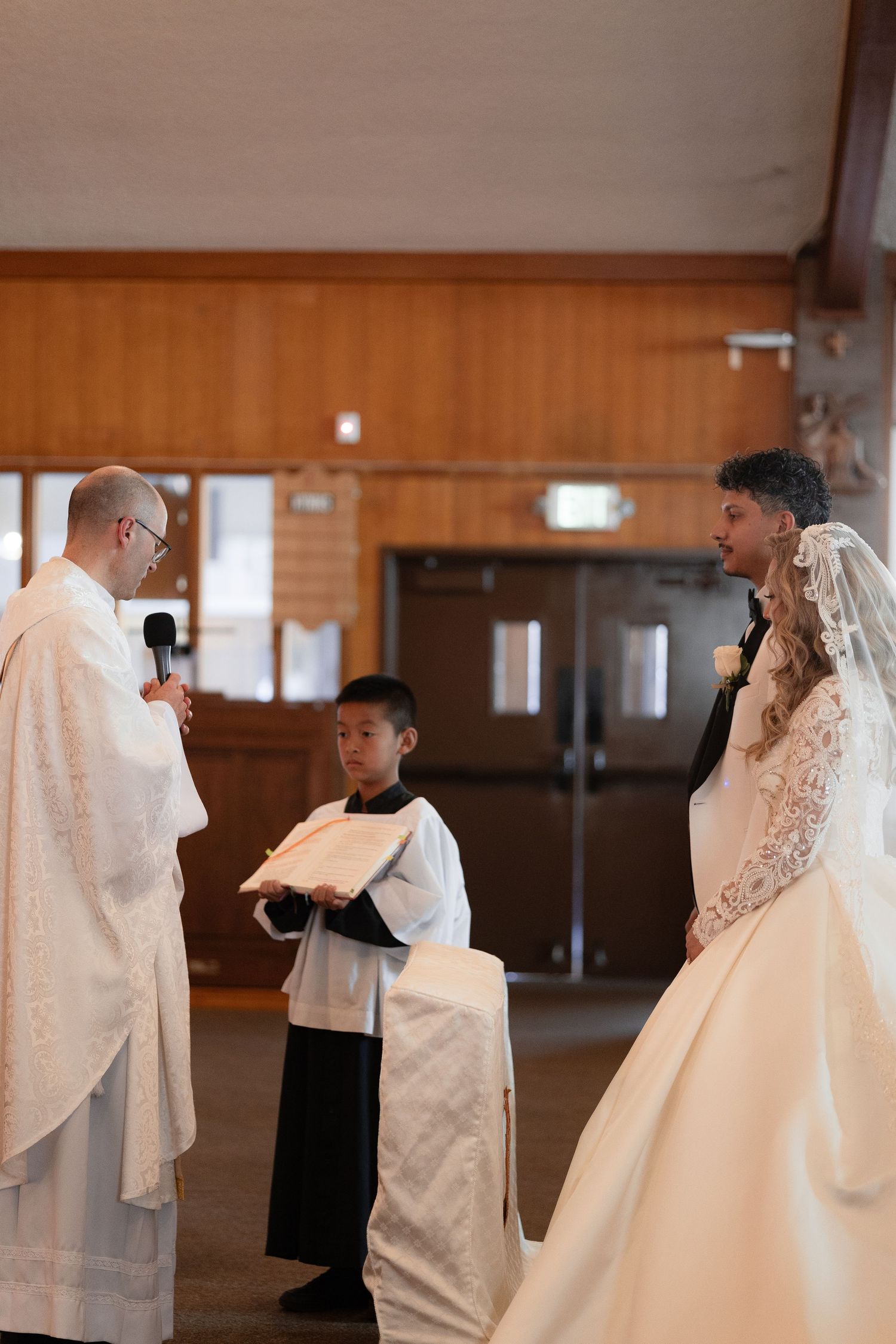 Wedding party standing in a church during a traditional ceremony.