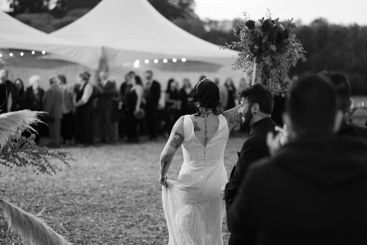 A bride in a white dress twirls on the dance floor under string lights.