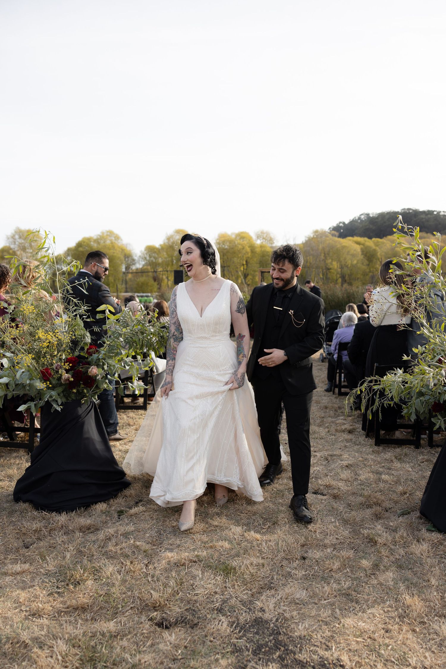 Wedding party members walking through desert landscape during outdoor ceremony.