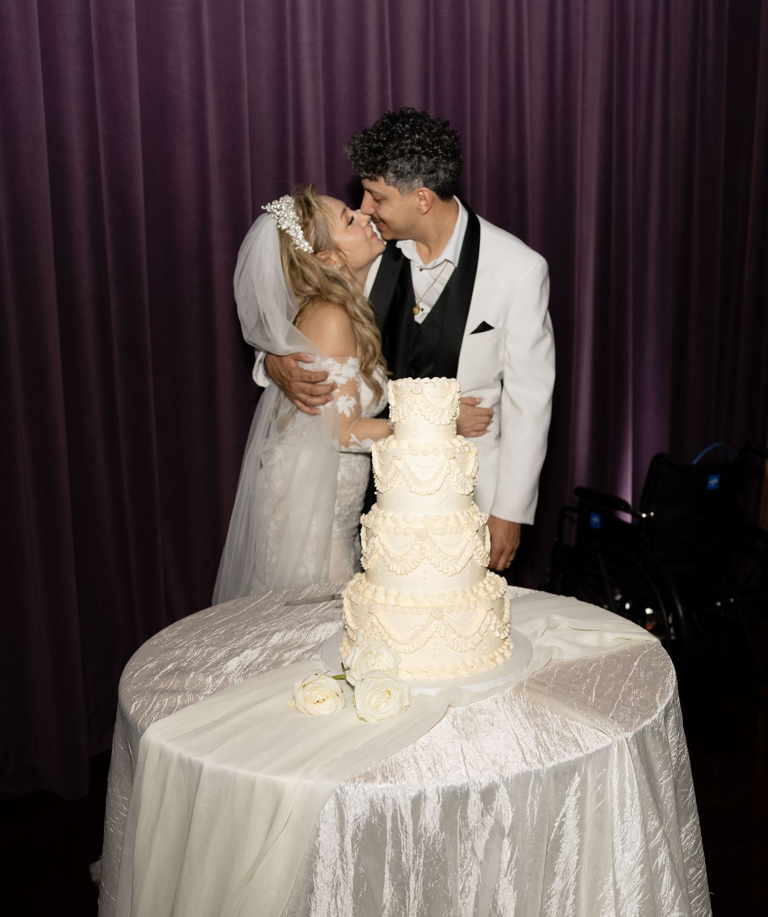 Wedding couple cutting their traditional white tiered cake at the reception.