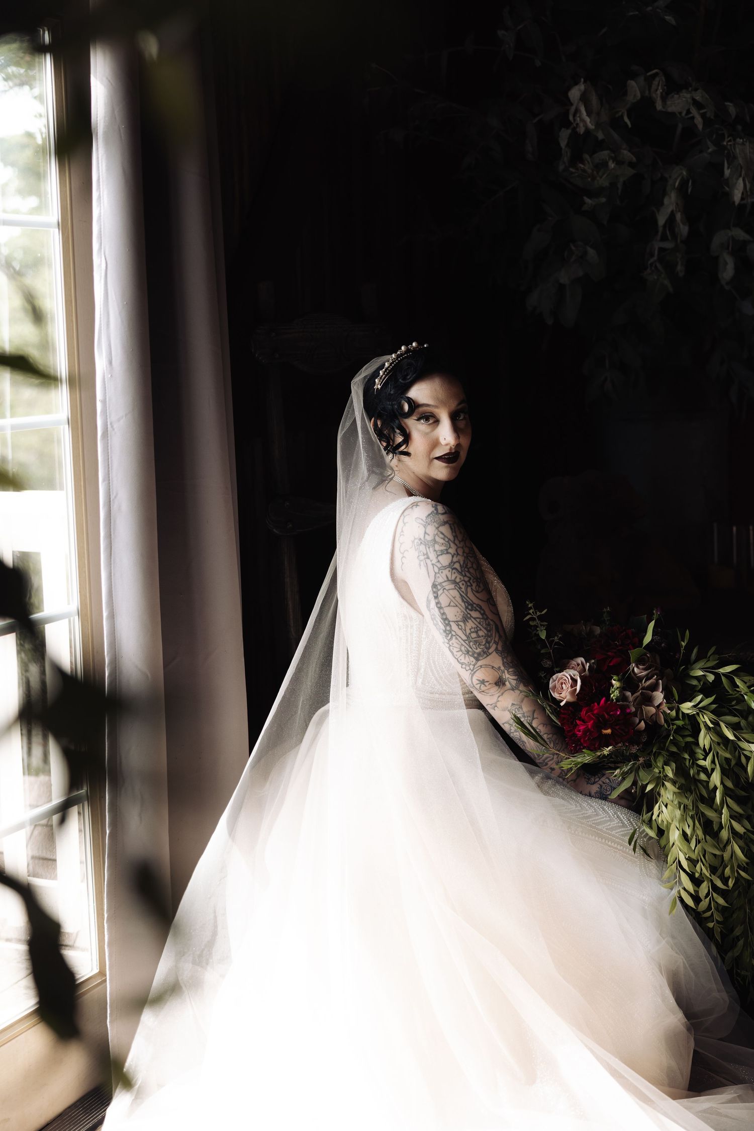 Ethereal bridal portrait with flowing veil in natural window light.