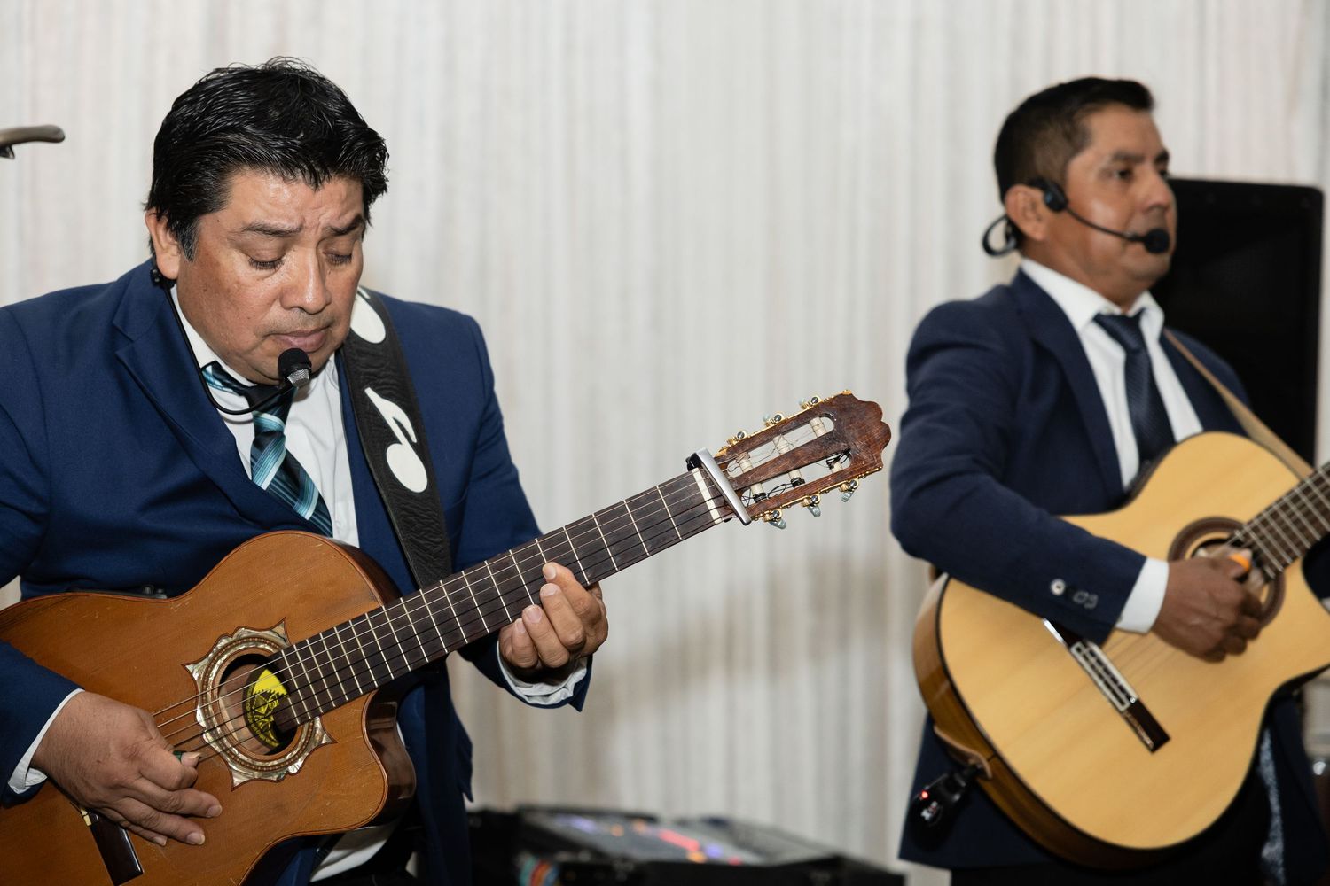Guitar ensemble performs classical music in formal navy suits.
