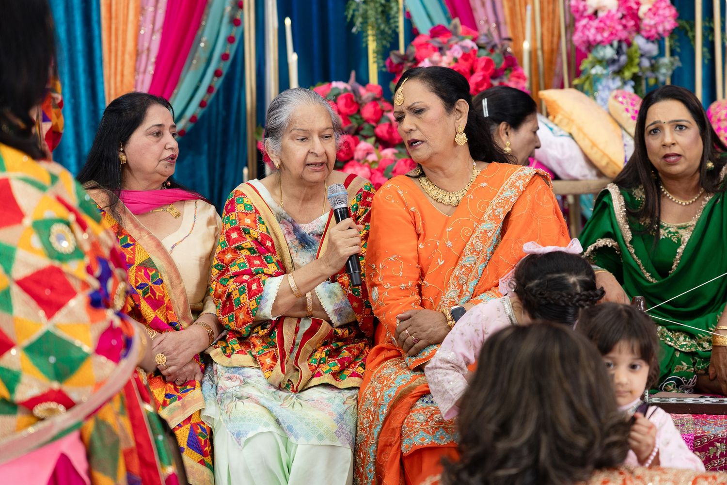 Colorful crowd gathering at a festive Indian wedding celebration with vibrant saris and traditional attire.