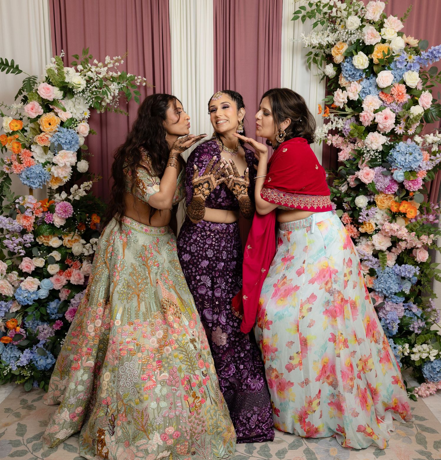 A series of photos showing people in colorful floral dresses posing against a floral backdrop at a celebration.