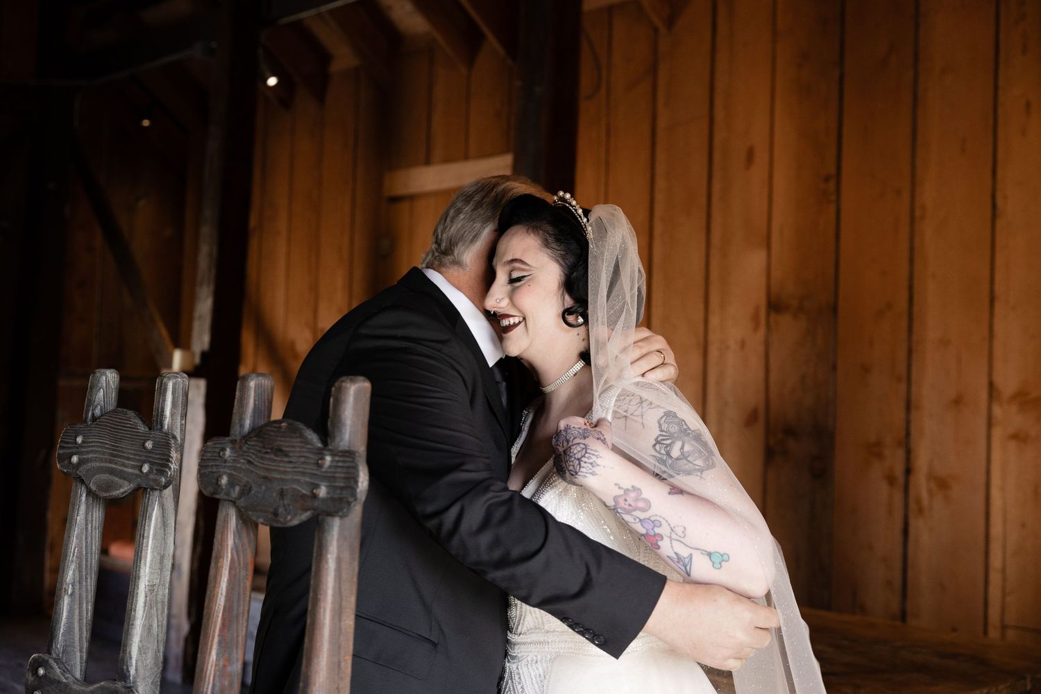 A romantic first look moment between a couple in a rustic barn setting with wooden walls and natural lighting.