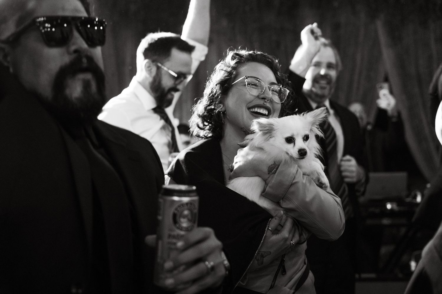 Black and white photo showing animated dancing at wedding reception.