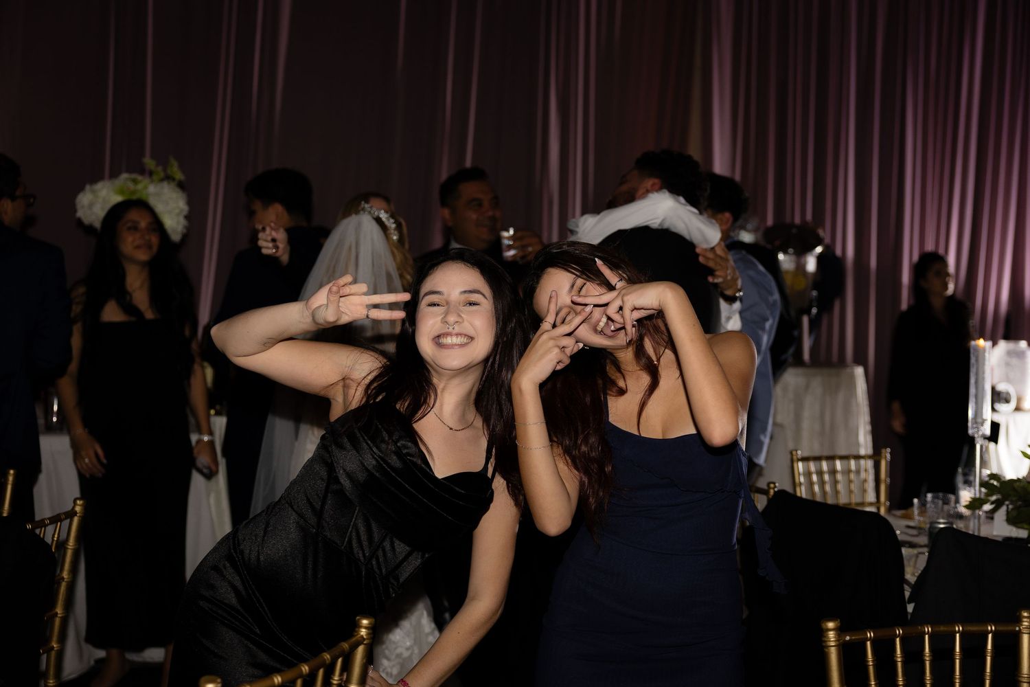 Wedding party guests dancing and celebrating at a lively reception.