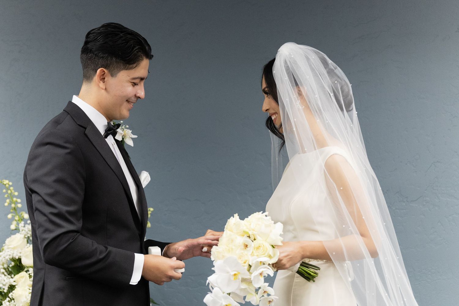 Candid wedding portrait moment with couple and white floral decorations.
