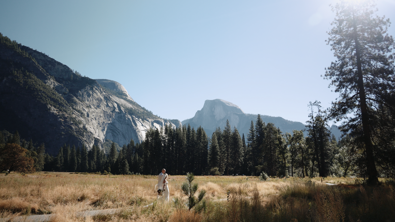 Panoramic view of Yosemite Valley with El Capitan and Half Dome visible in the distance.