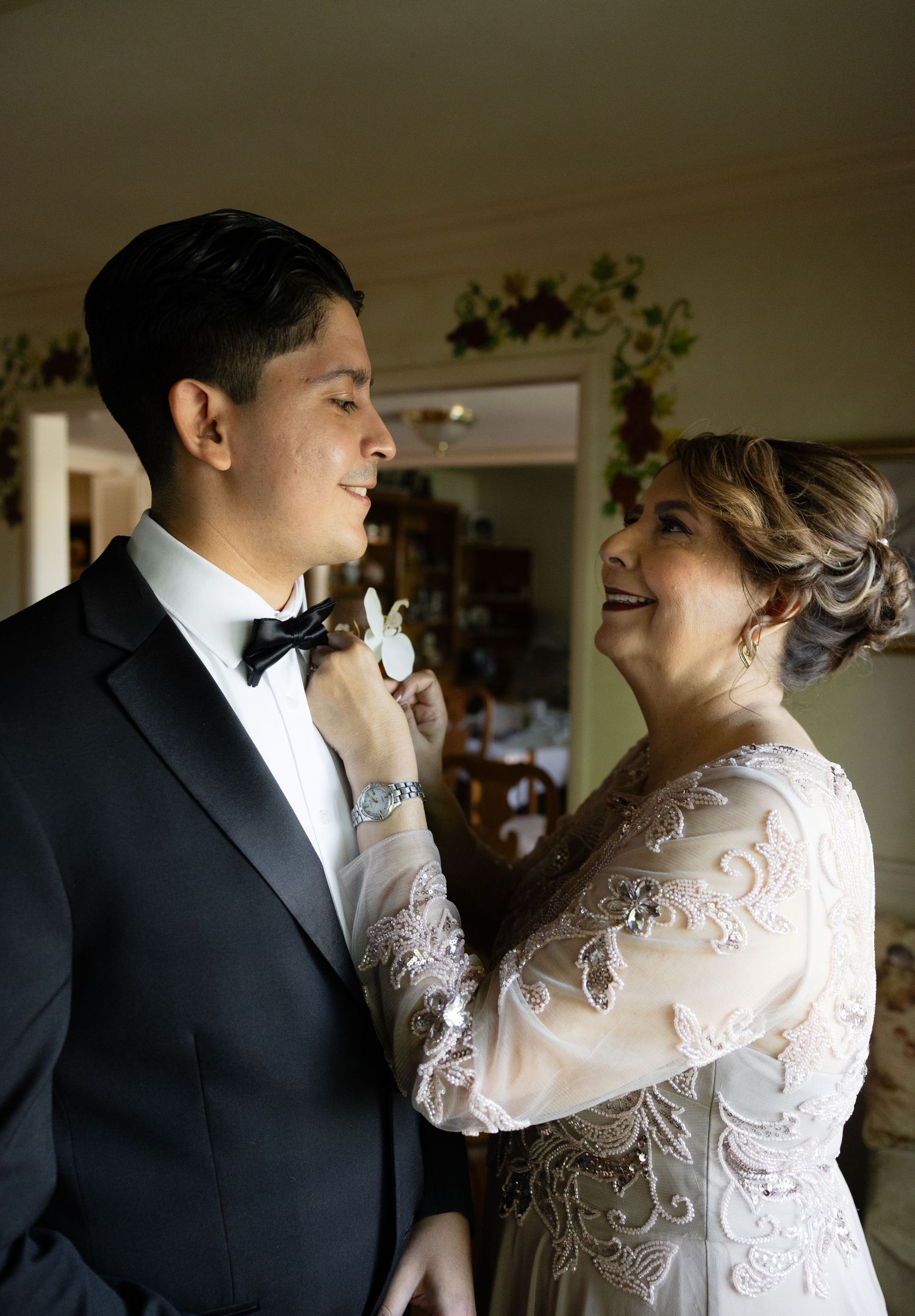Romantic moment captured between newlyweds in formal wedding attire against neutral background.