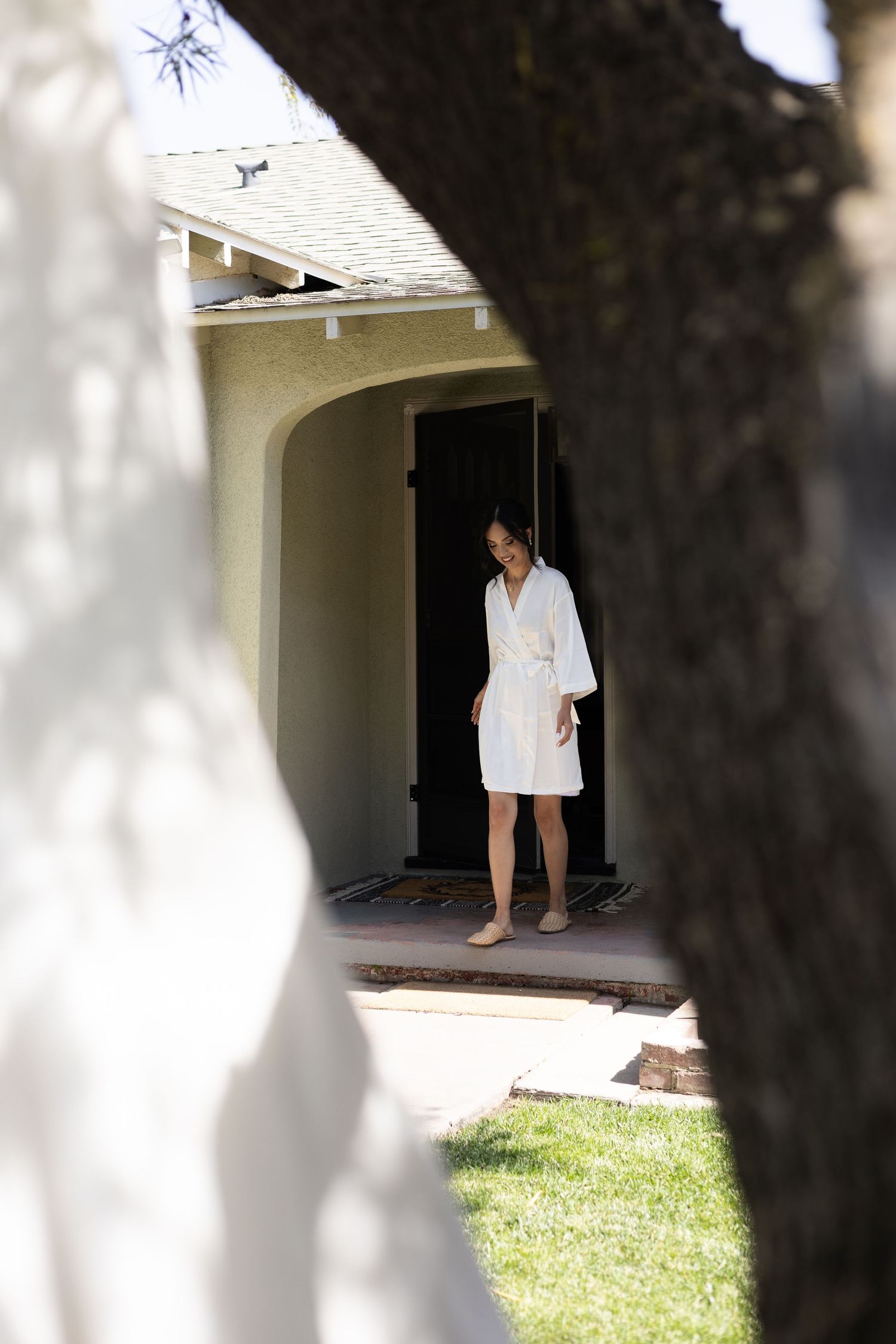 Getting ready scene through doorway showing white robes in morning light.