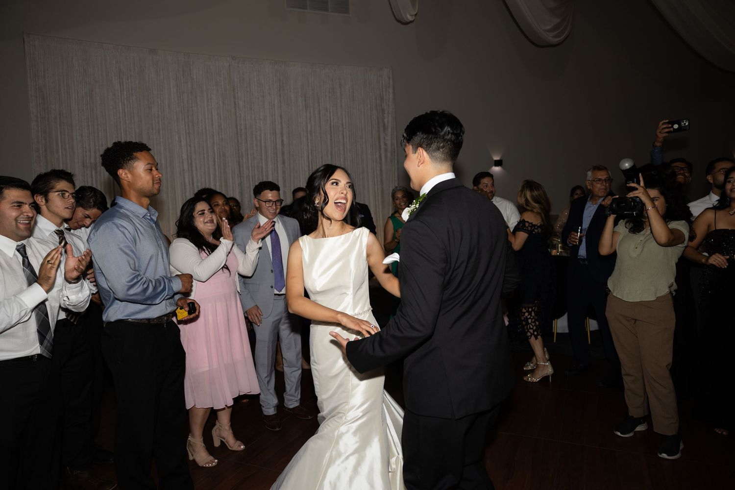 Guests enjoying a lively dance party at an indoor wedding reception venue.