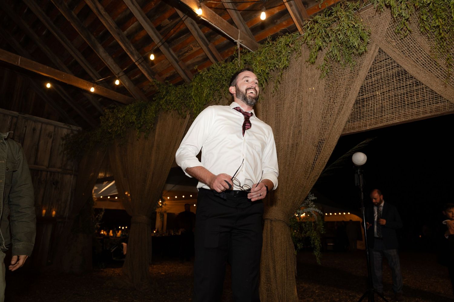 Festive dance party scene in a barn with exposed wooden beams and ambient lighting.