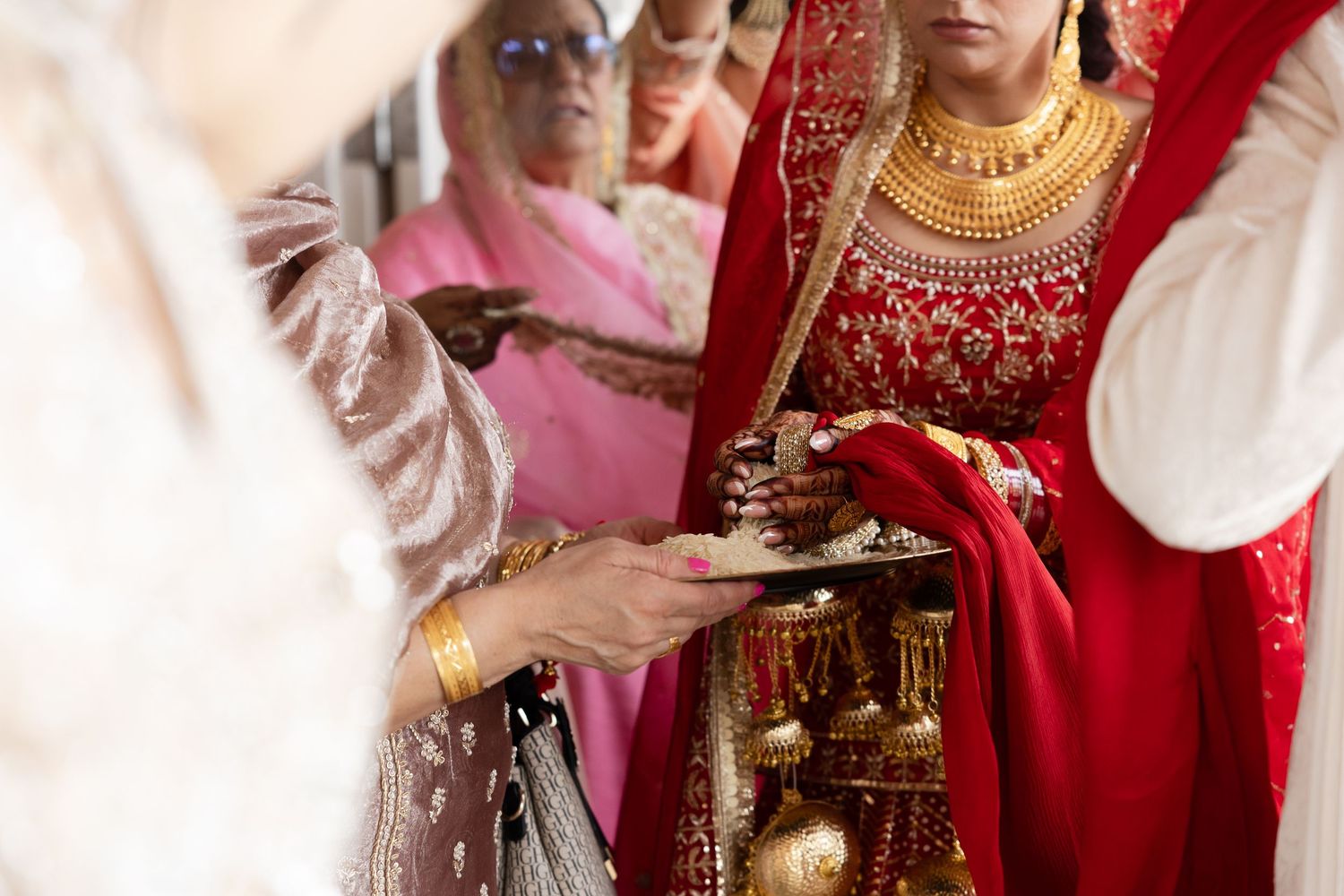 Traditional Indian wedding ceremony with ornate red and gold decorations and ceremonial items.