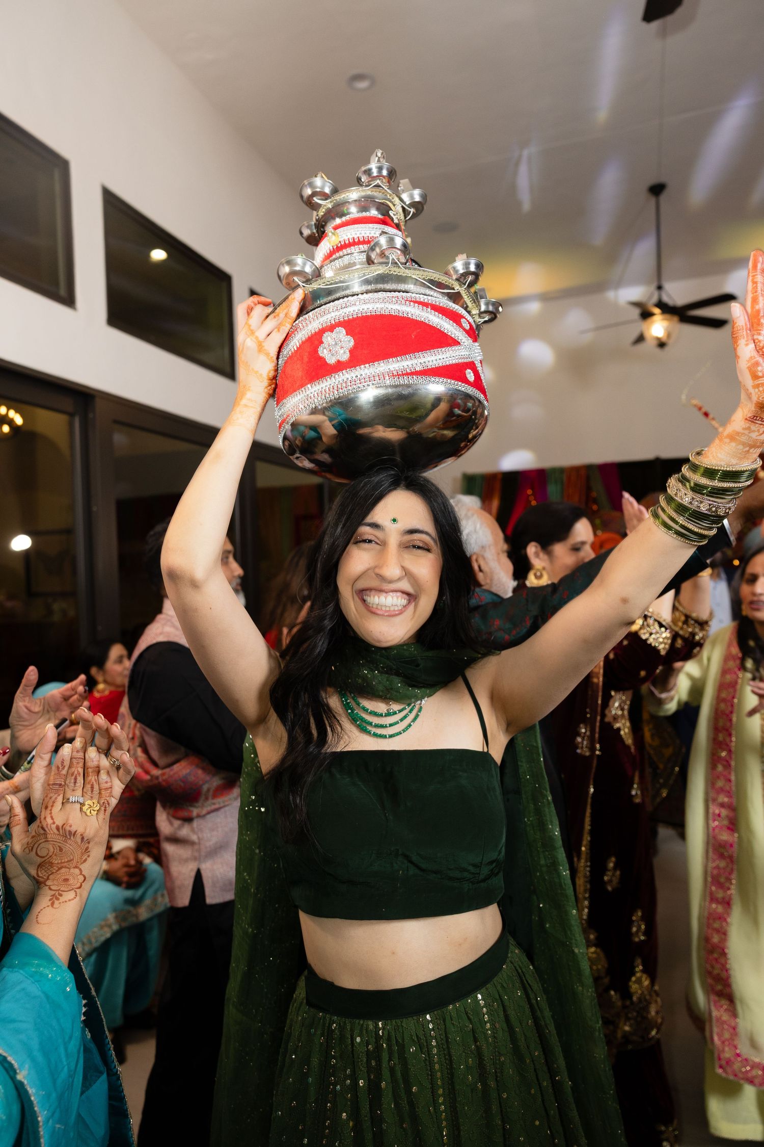 Festive celebration with people dancing and wearing decorative crowns at an indoor party.