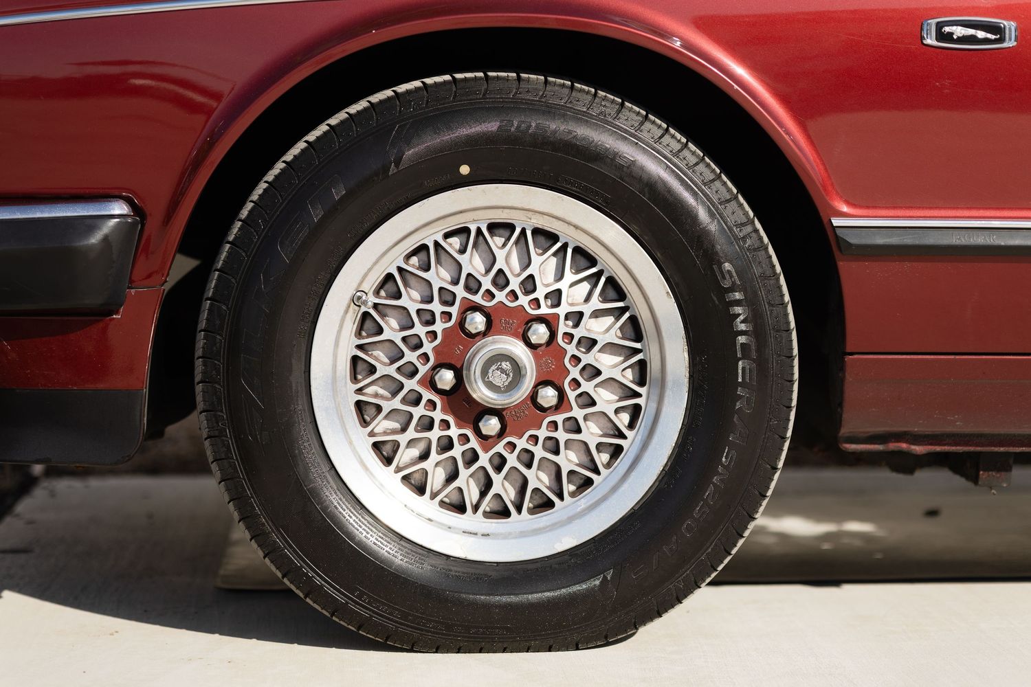 A series of six close-up shots showing red car panels and silver mesh wheels with detailed spoke patterns.
