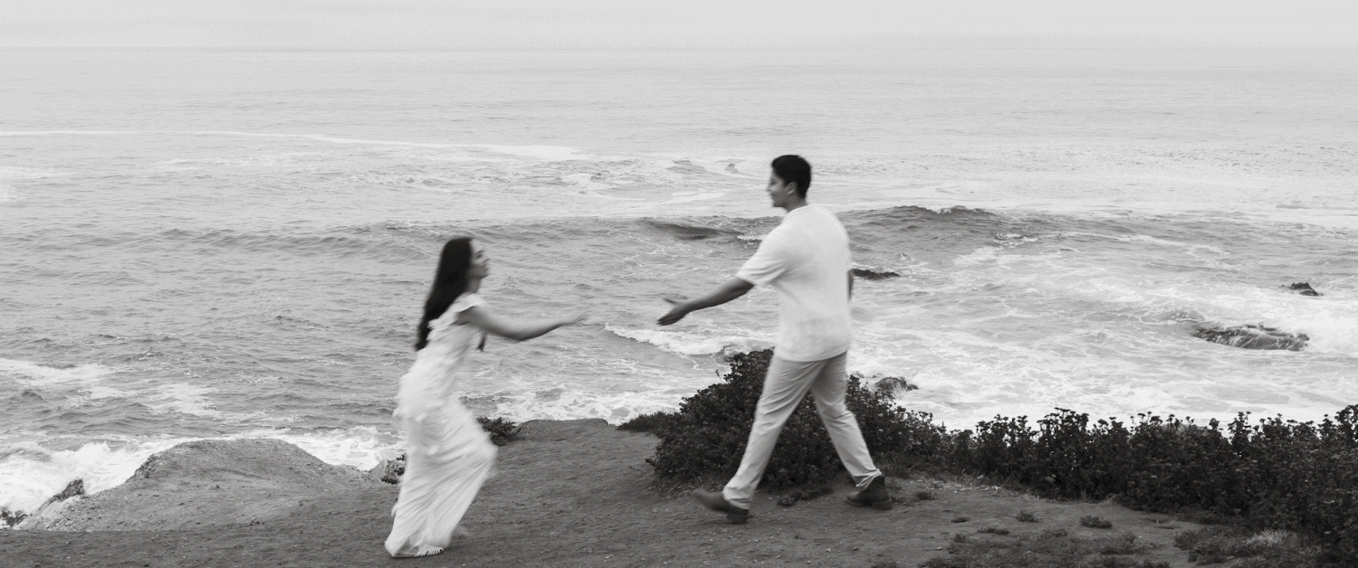 A gif of two people reaching out for each other during an engagement session on a cliffside beach.