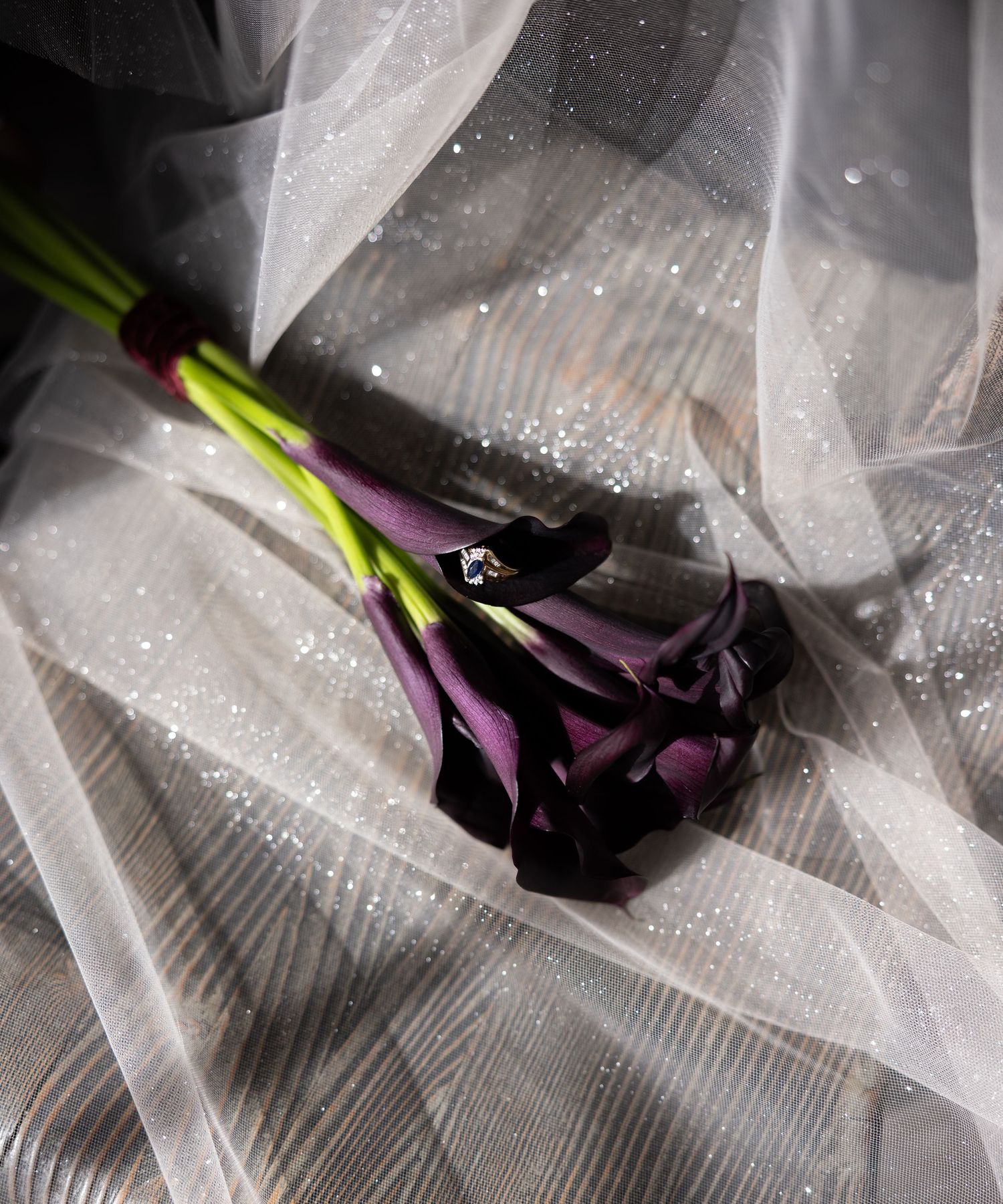 Purple calla lilies wrapped in delicate tulle fabric with sparkly details.